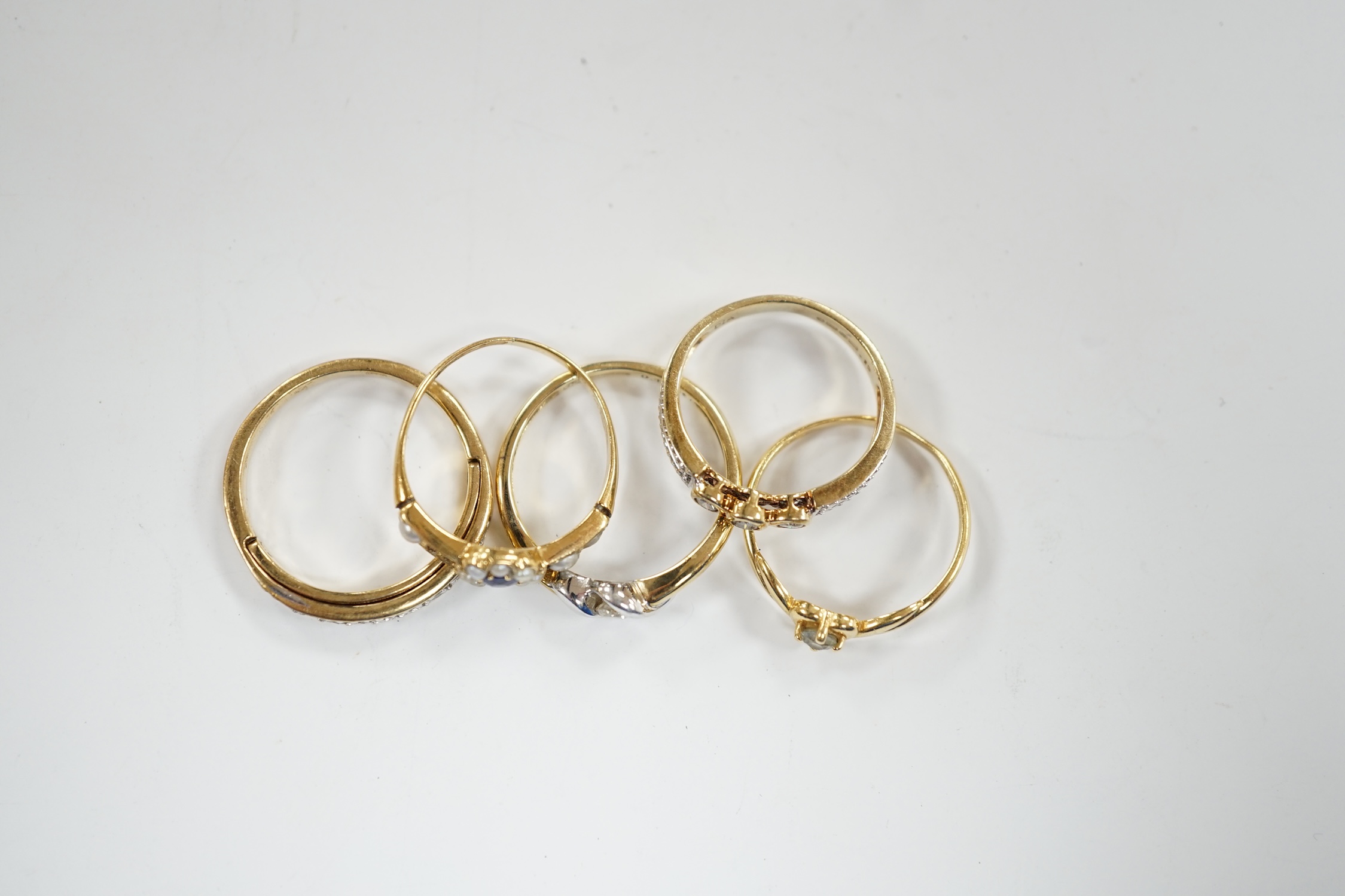 Three assorted modern 9ct gold and diamond set rings, gross 6.5 grams and two other yellow metal and gem set rings.
